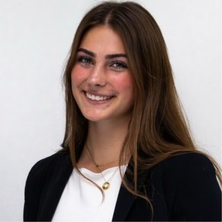Campbell Endries smiling, with long brown hair, in a black blazer.