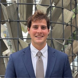 Jaret Solomon smiling in a navy suit and tie.
